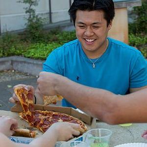 获得奖学金的学生与同学一起享用披萨