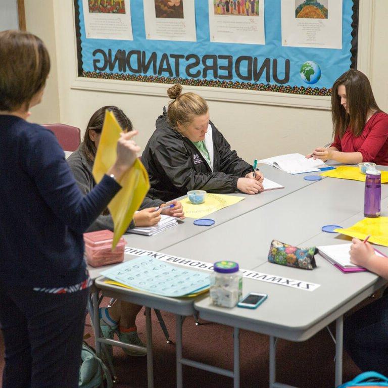 Dyslexic students practicing their writing skills at a table