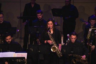 A female student plays the saxophone during a jazz ensemble performance.